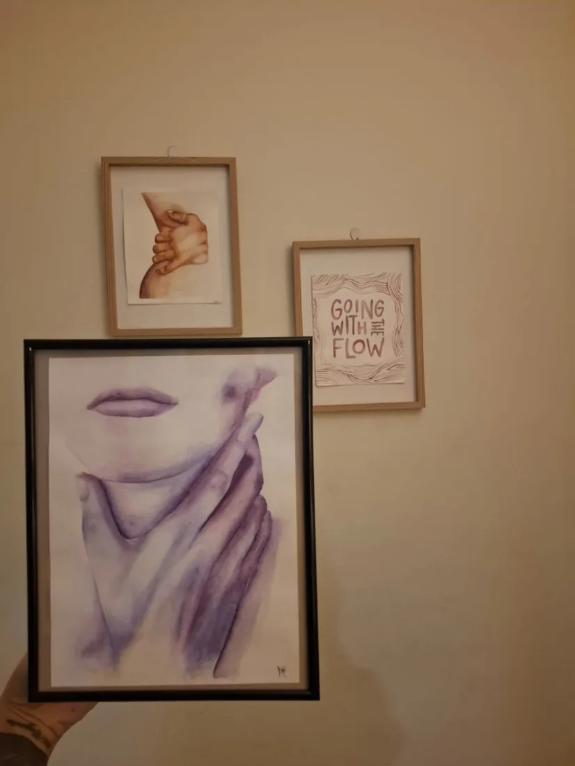 Dos acuarelas de Milena enmarcadas, colgadas en la pared de una casa.